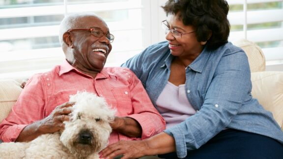 Cuple happy with their dog. You should put your pet in your estate plan to make sure it's taken care of.