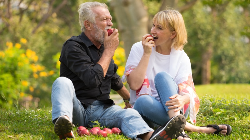 Two seniors eating apples.