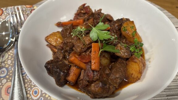 A bowl of beef stew with sun-dried tomatoes