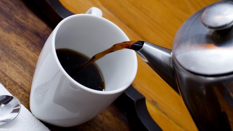 Coffee being poured into a white mug