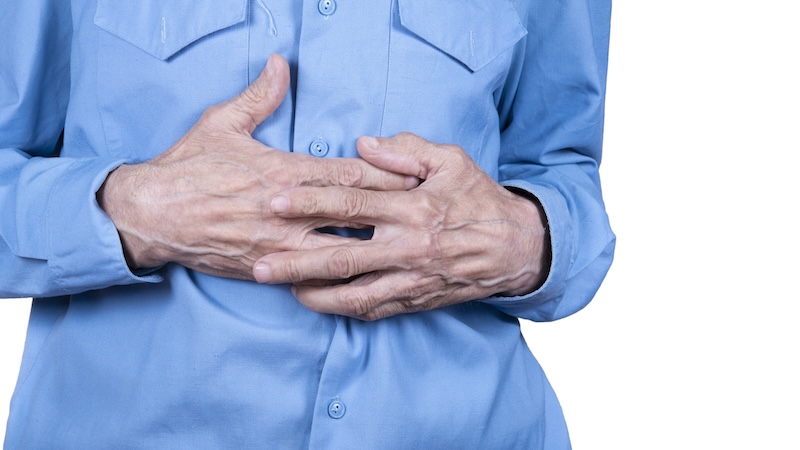 A man holding his stomach wondering about ways to improve gut health