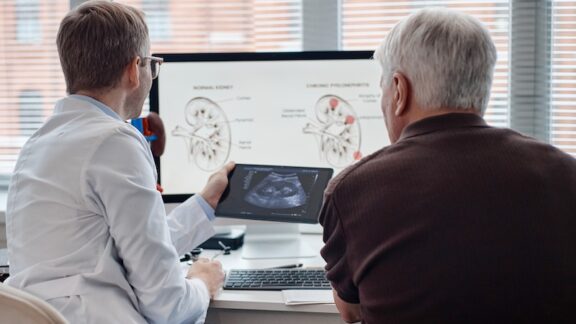 A man struggling with urinary incontinence looking at an x-ray with his doctor.