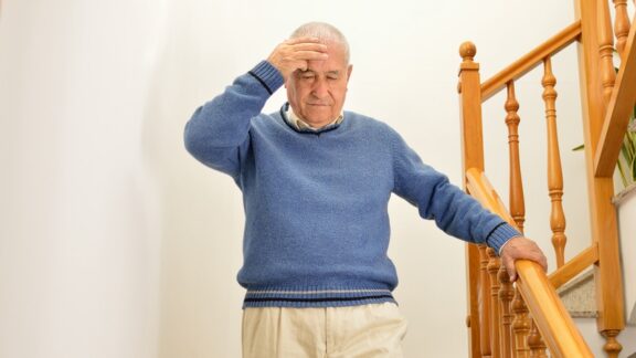 Man going down stairs experiencing dizziness and hunger pains