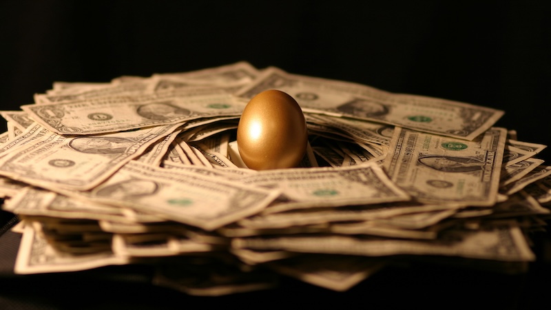 A golden egg in the middle of money representing a 401k loan
