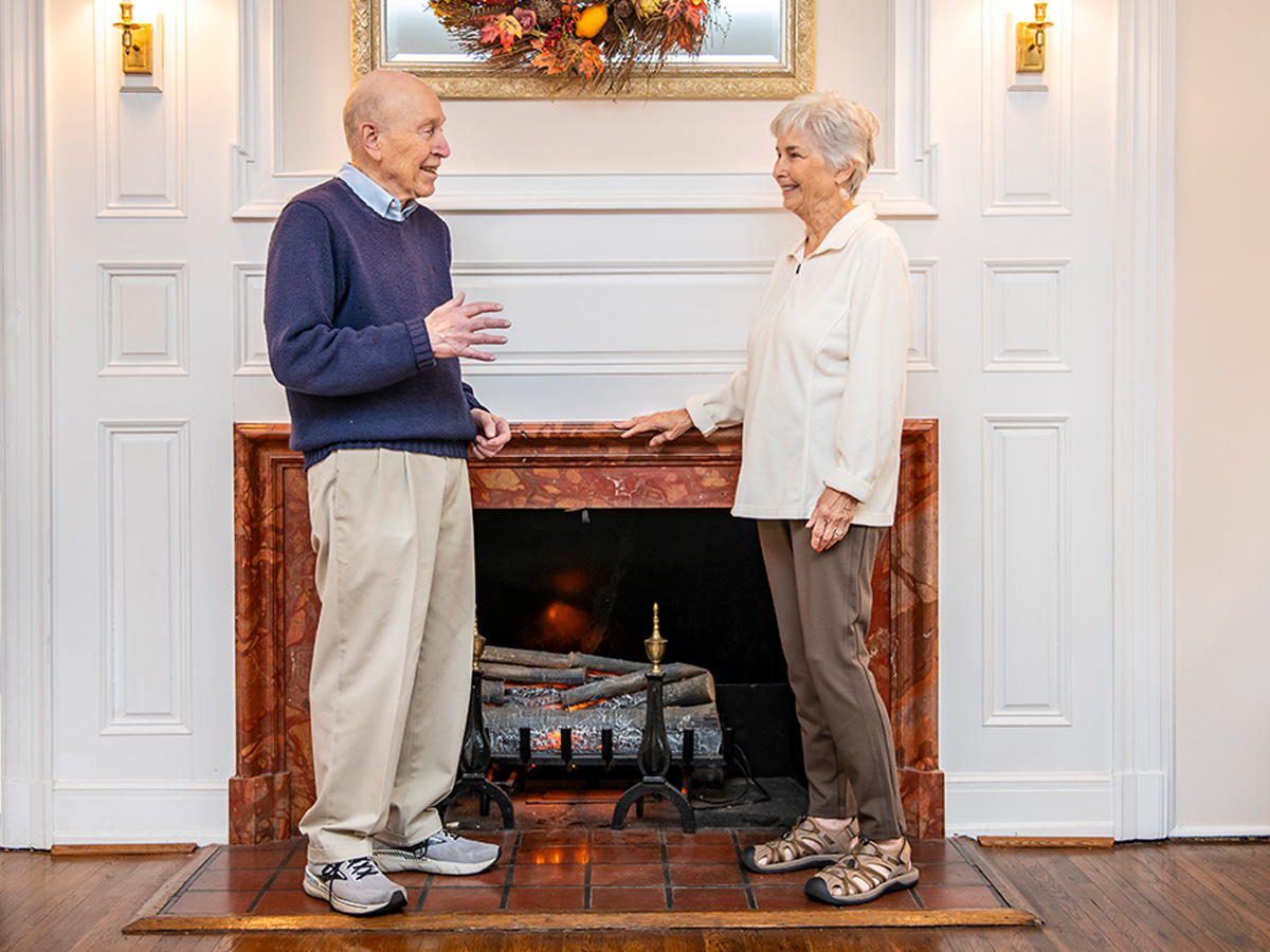 Hermitage Roanoke Couple Talking in Front of Fireplace
