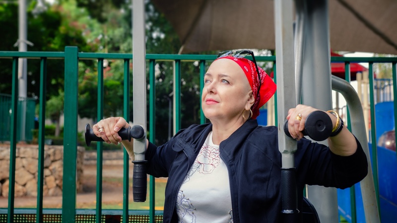A woman on a fitness machine getting exercise during cancer treatment.