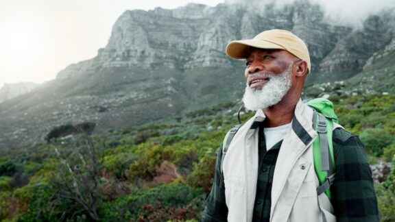 A man hiking in the mountains taking a sabbatical to postpone retirement.