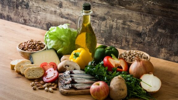 Fresh ingredients like olive oil and peppers common in Mediterranean recipes. The Mediterranean diet is heart healthy.