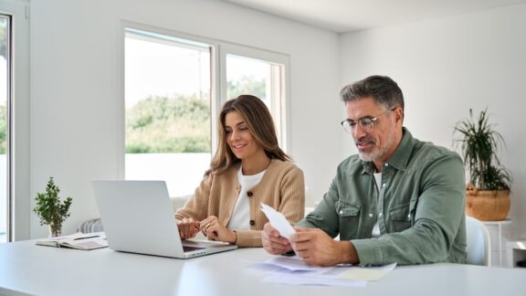 A couple at a computer learning how they can tame taxes in retirement.