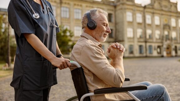 A man with dementia listening to music in a wheelchair