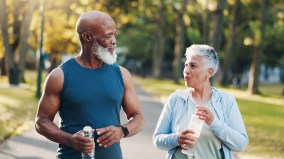 Two seniors outside staying hydrated, one of the benefits of electrolytes