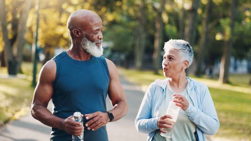 Two seniors outside staying hydrated, one of the benefits of electrolytes