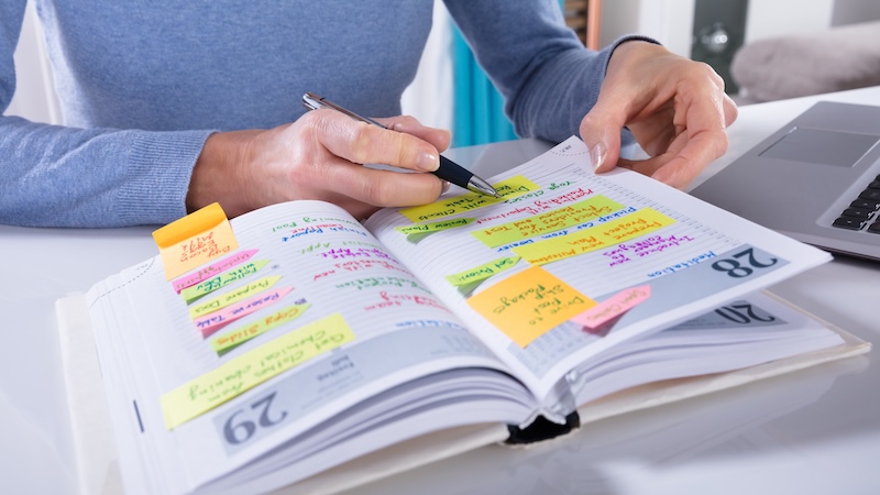 A senior marking her calendar because of forgotten appointments.