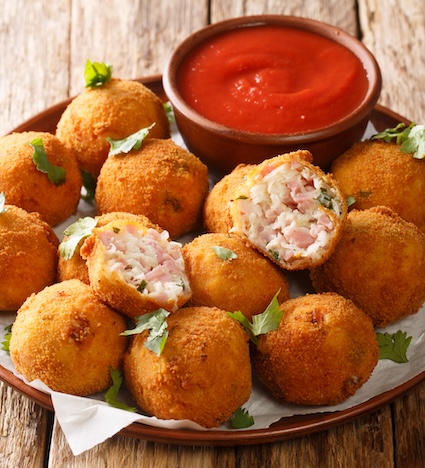 Delicious appetizer Sauerkraut balls with ham close-up in a plate on the table.