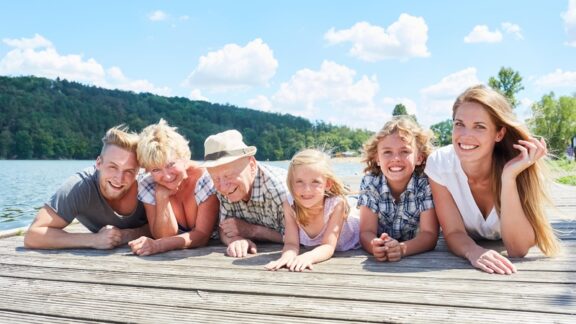 Family having fun on a lake dock making sure to follow water safety tips.
