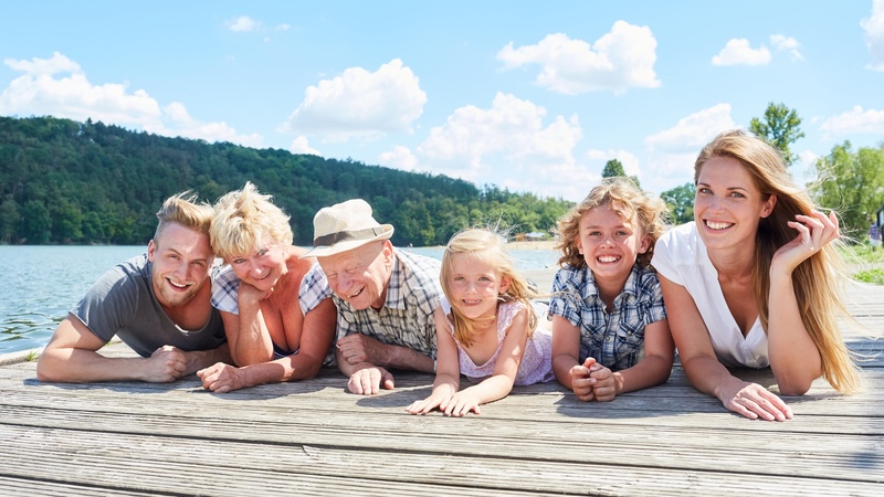 Family having fun on a lake dock making sure to follow water safety tips.