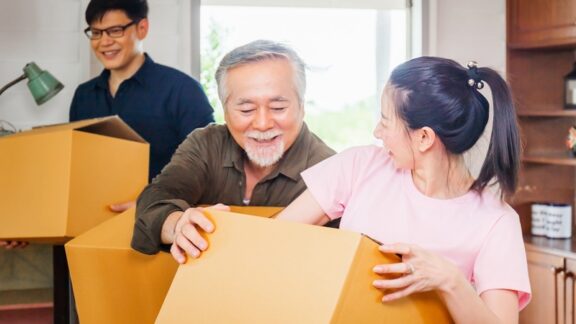 A senior dad following grown kids helping them move.
