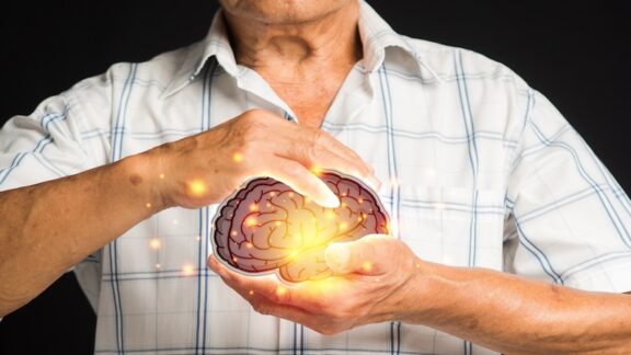 Man holding an artificial intelligence brain, signifying using AI for retirement planning. boonstocker