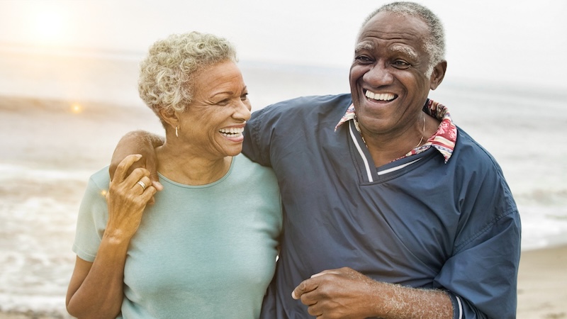 Black senior couple on a beach happy in retirement