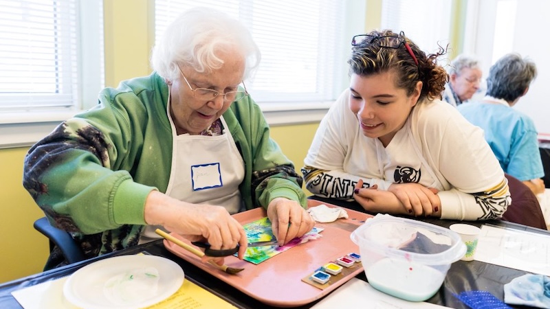 A participant and volunteer making arts as part of Opening Minds Through Art, reaping the benefits of art for people with dementia