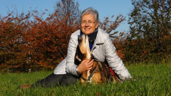 A senior woman outside with her dog.