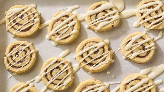Cinnamon roll cookies with icing drizzled on top.