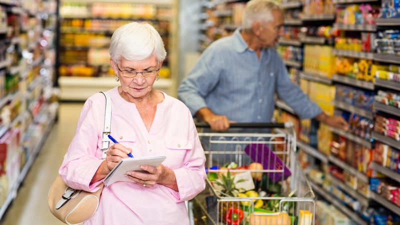 An older couple shops carefully on days with hidden senior discounts