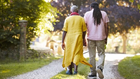 A couple walking in their neighborhood, realizing that daily steps provide health benefits. Monkey Business Images