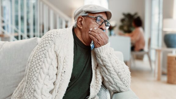 A man with pneumonia coughing into his hand