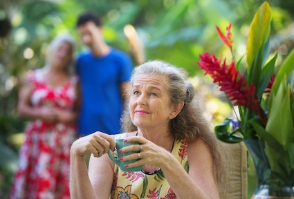 A woman staring up, oblivious to the couple behind her, who are worried their loved one may have dementia. Creatista