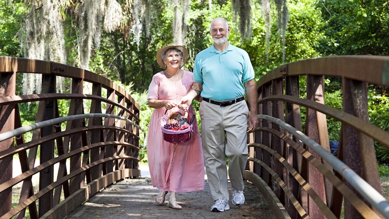 A couple strolling in a Florida park. Reflecting the cost of senior living in Florida. Brian T. Young