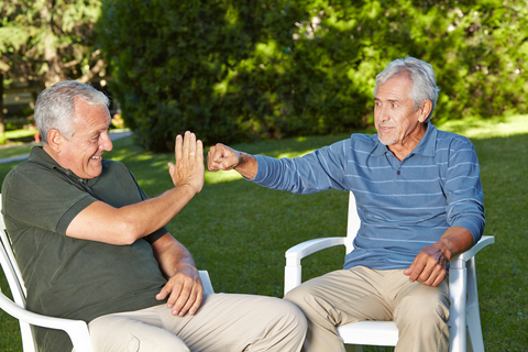 Two men outside in their yard, using shared housing for seniors. Robert Kneschke