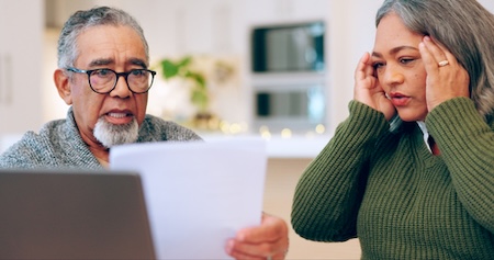 A couple looking at a their finances, worried about the 2027 Social Security COLA. Yuri Arcurs
