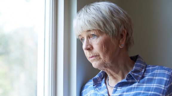 Woman looking out of the window wanting to love people but needing alone time.