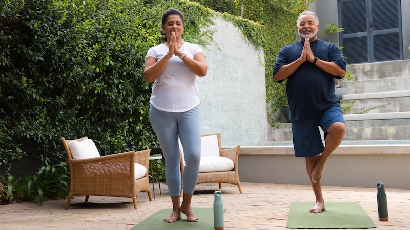A couple outside, knowing the matter of balance is important, exercises that sense by standing on one foot. Wavebreakmedia Ltd