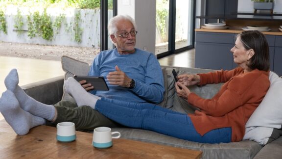 A couple relaxes in their family room, having decided to stay close to home in retirement. Wavebreakmedia Ltd