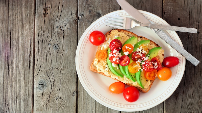 A Mediterranean style breakfast with avocado, tomatoes, and feta cheese.